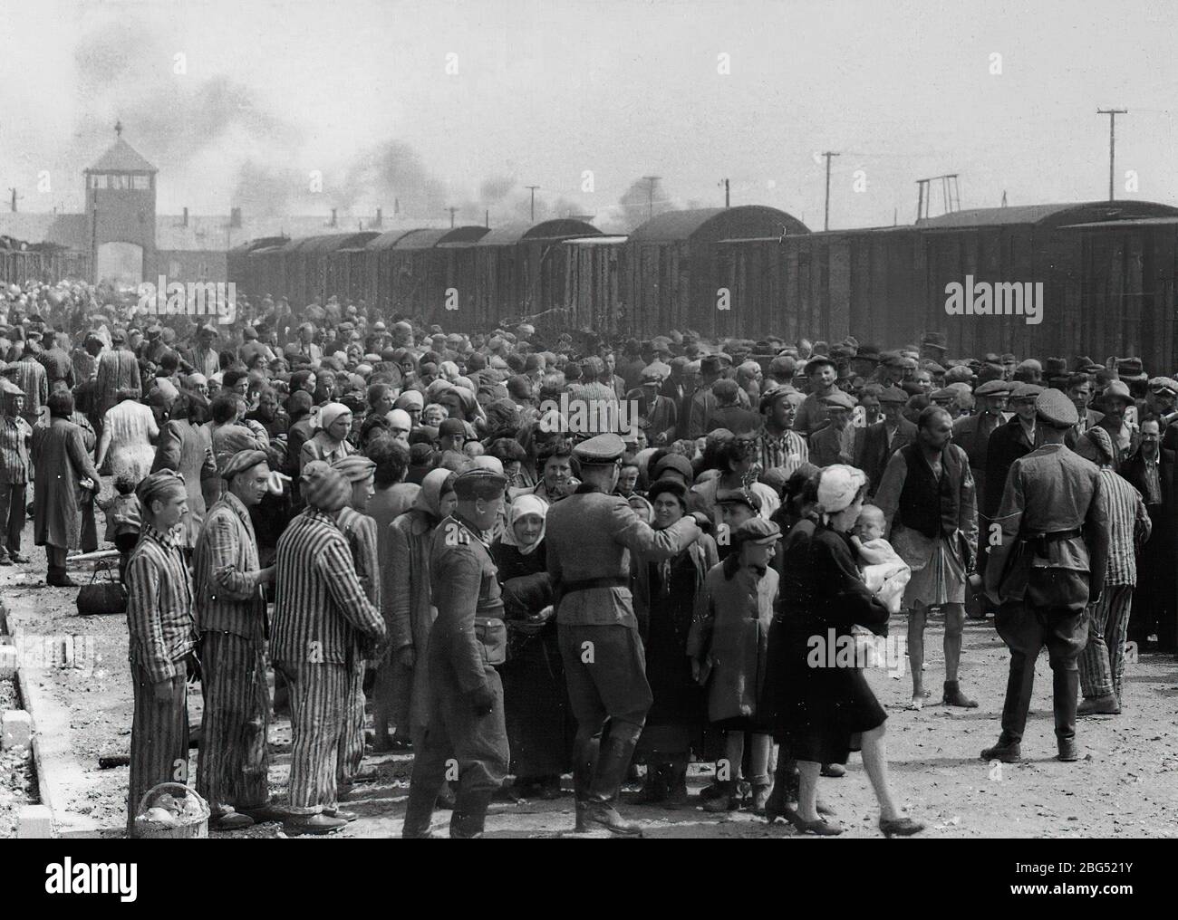 Documentario sulla seconda guerra mondiale. Le guardie naziste si radunano all'arrivo dei prigionieri sulla rampa di scarico del campo di concentramento di Auschwitz, circa maggio/giugno 1944 Foto Stock