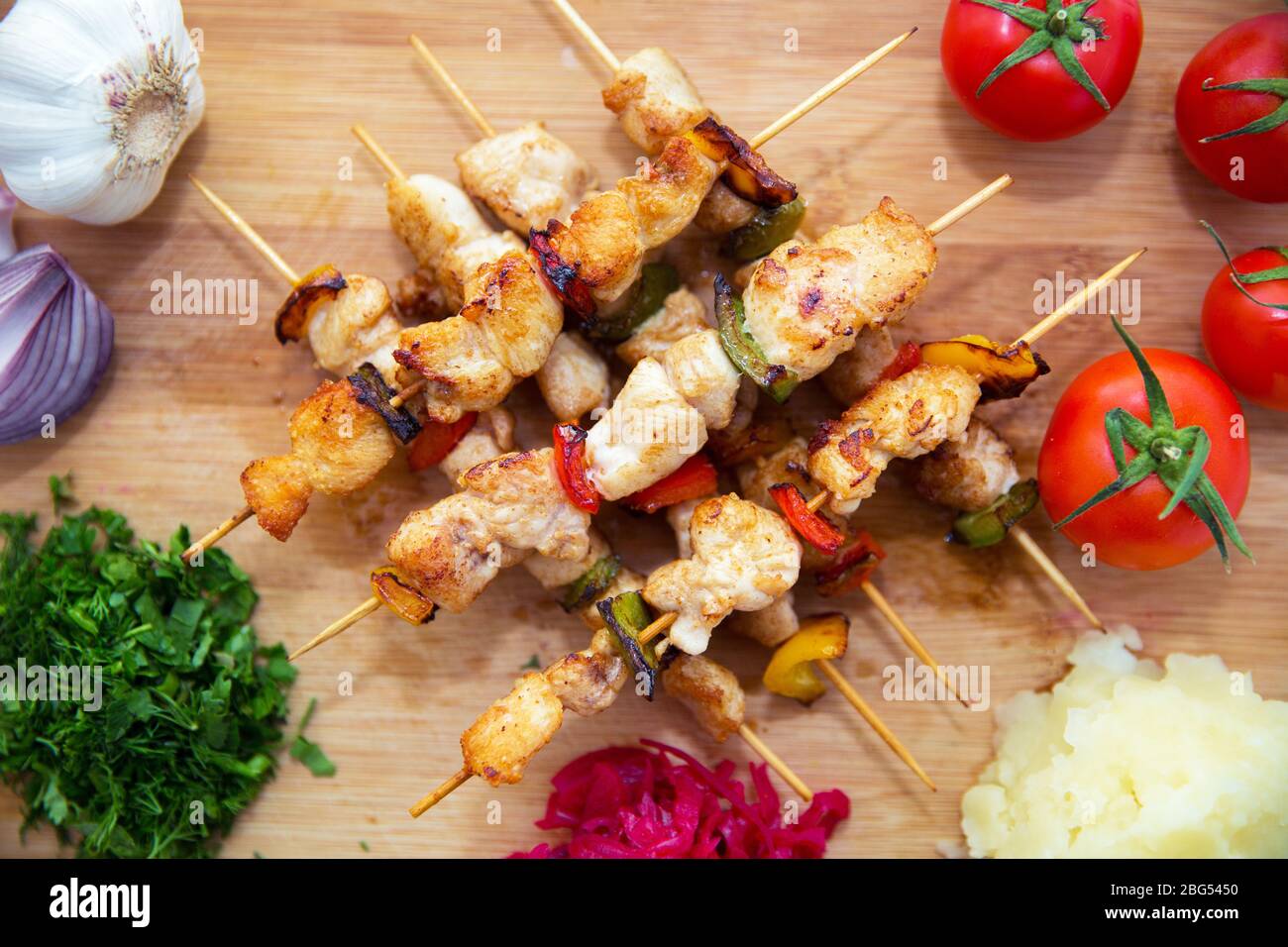 Set di Shish Kebab . Kebab di manzo su un asse di legno . Crauti di cavolo rosso . purè di patate . Aglio, cipolla, pomodori. Coriandolo tritato . Agnello Foto Stock