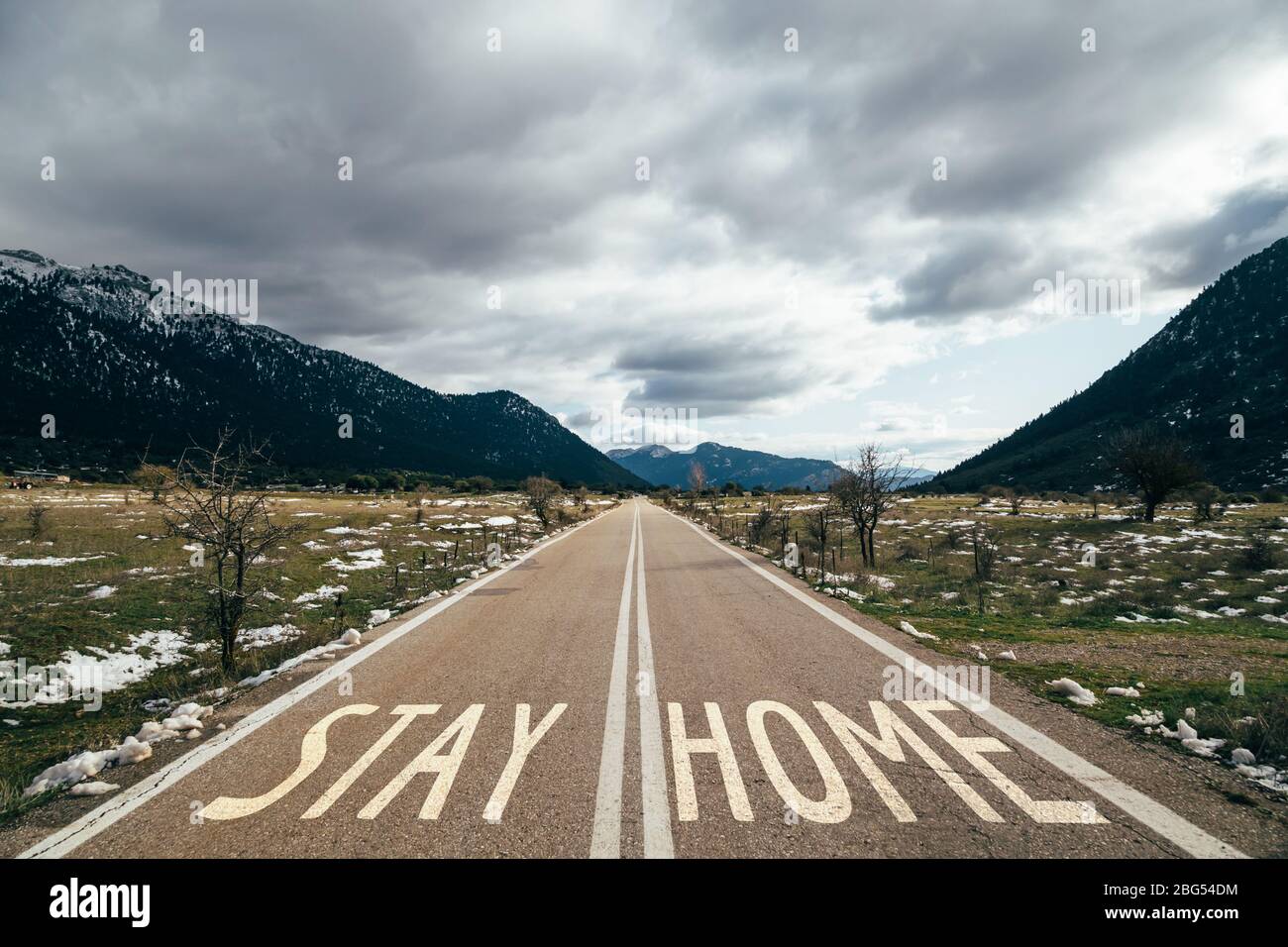 Segnale di avvertimento stradale soggiorno a casa scritto su asfalto sulla strada, campagna dei social media per la prevenzione del coronavirus. Soggiorno a casa concetto di sicurezza Foto Stock