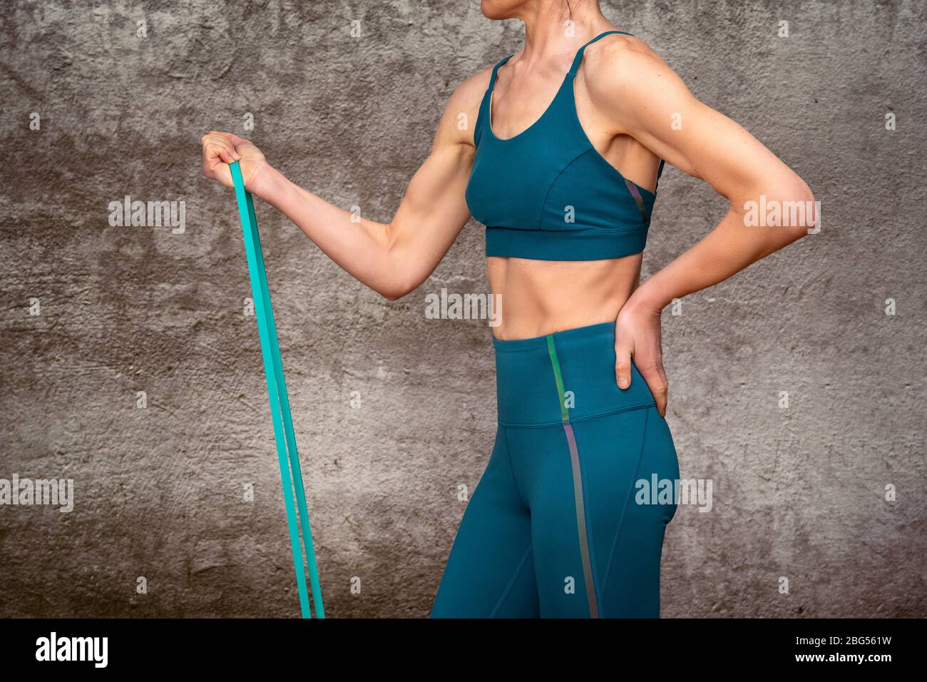 Primo piano di una donna che utilizza una fascia di resistenza per mantenere la forma e l'esercizio fisico Foto Stock