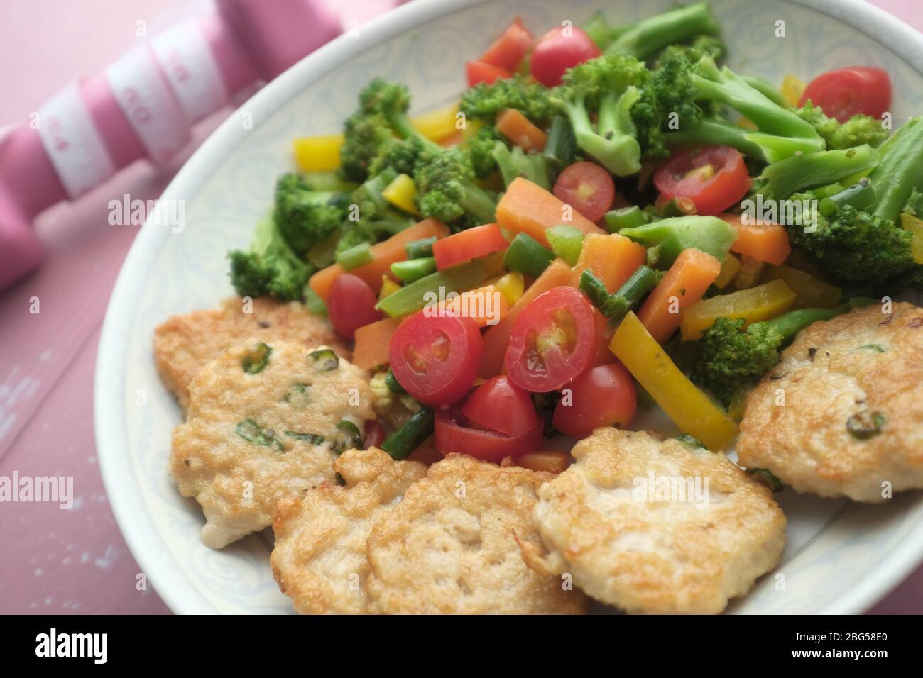 Pepite di pollo fritte e insalata sul piatto. Foto Stock