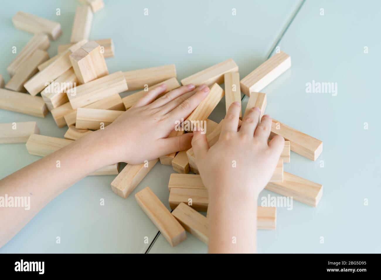 Mani ravvicinate di ragazzino giocare con mattoni di legno gioco Foto Stock