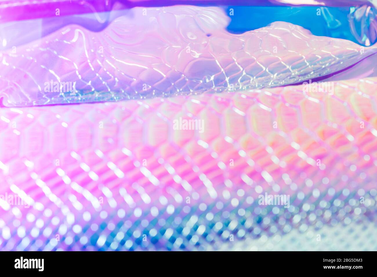 Astratto sfondo di serpente sfocato. Pelle serpente argento neon motivo texture sfondo Foto Stock