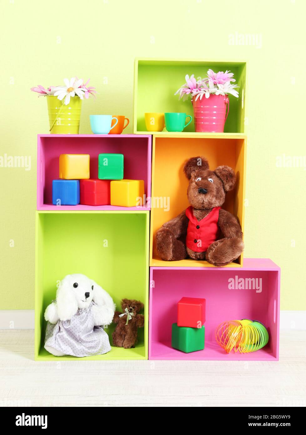 Scaffali luminosi di colori diversi con giocattoli sullo sfondo della parete Foto Stock