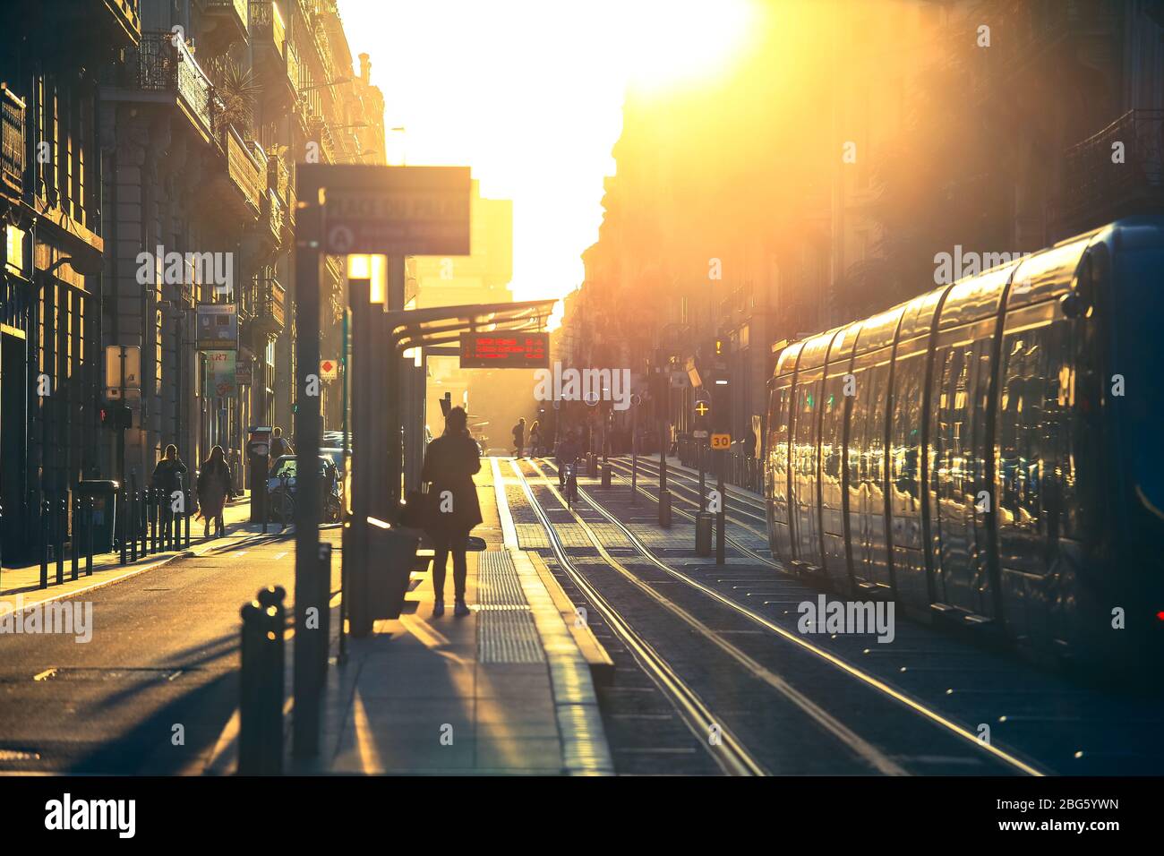 BORDEAUX, FRANCIA - 1 ottobre 2017 : scena di strada della città, fuoco selettivo sulle persone che camminano sulla strada con il tram durante il tramonto a Bordeaux, Francia Foto Stock