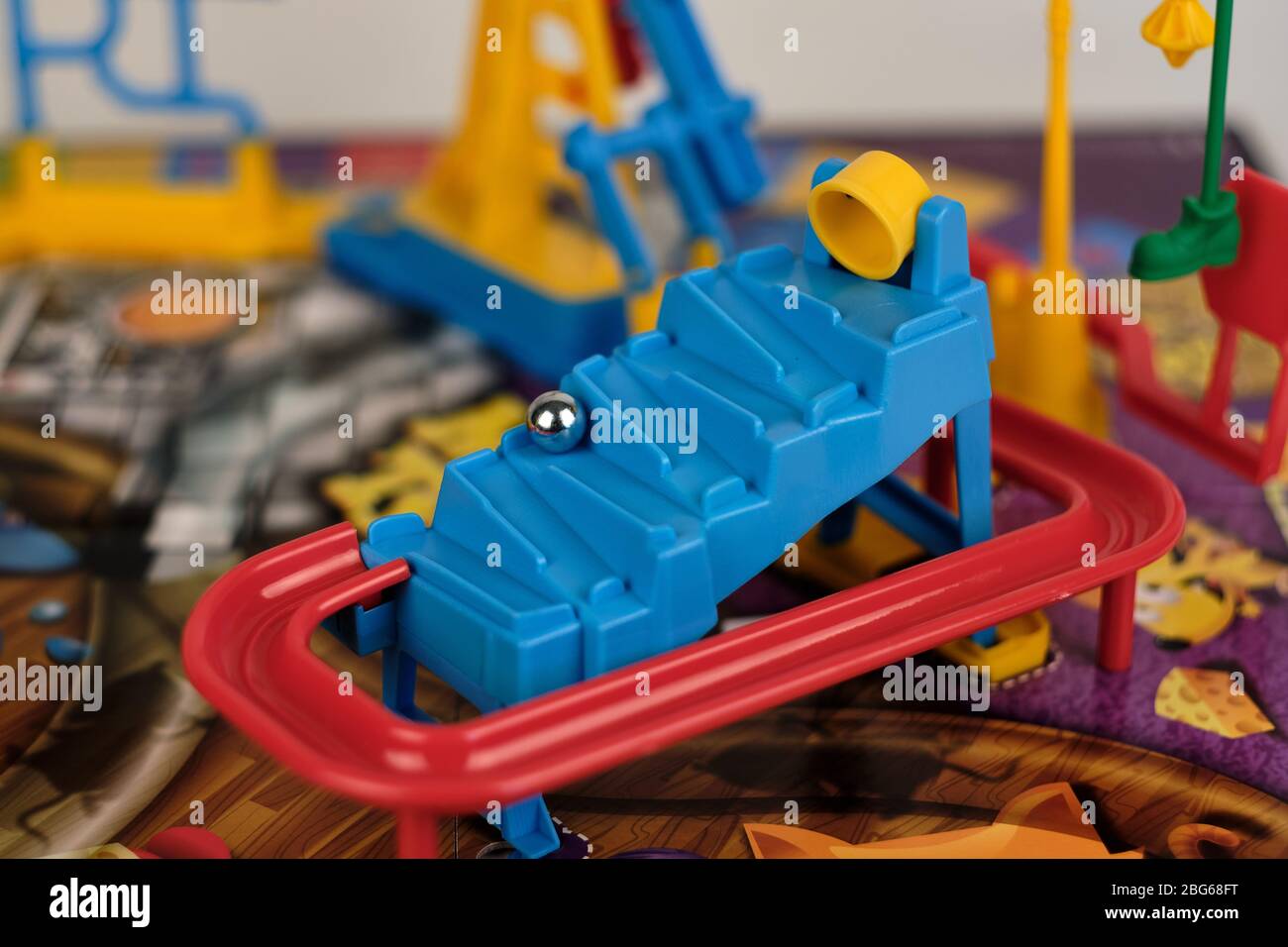 Primo piano del gioco da tavolo assemblato Hasbro mouse trappola con secchio giallo ribaltato e palla d'argento che rotola giù scale Foto Stock