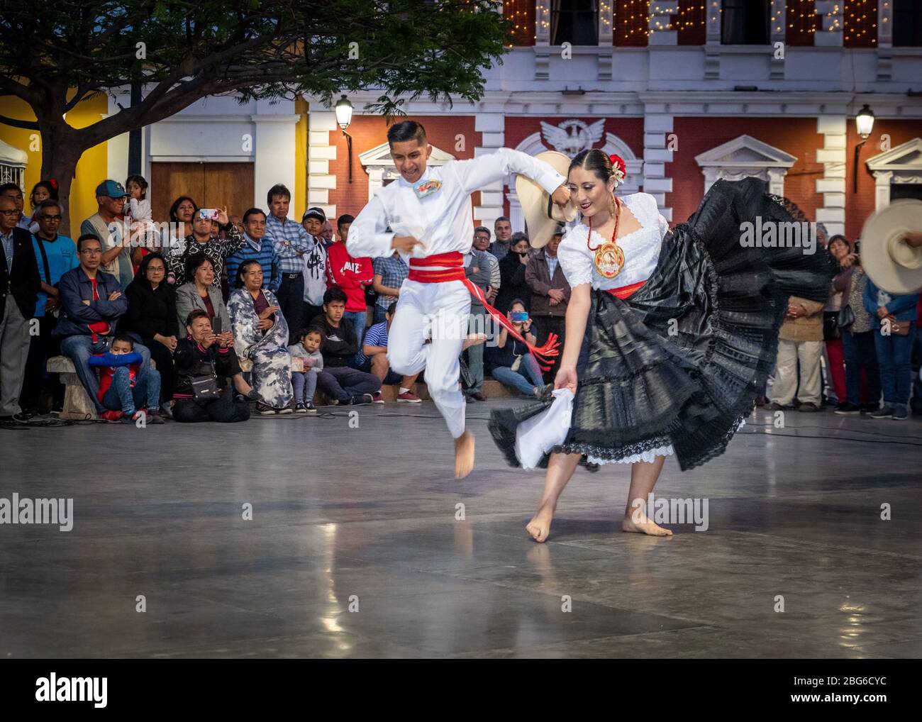 Ballerini maschili e femminili in costume tradizionale che eseguono la Marinera Norteña danza peruviana alla folla nella piazza principale di Trujillo nel nord del Perù Foto Stock