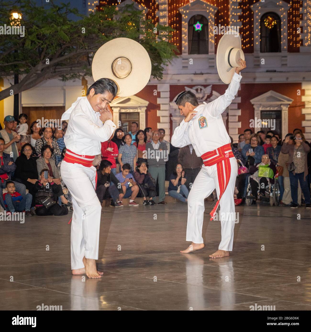 Ballerini maschili e femminili in costume tradizionale che eseguono la Marinera Norteña danza peruviana alla folla nella piazza principale di Trujillo nel nord del Perù Foto Stock