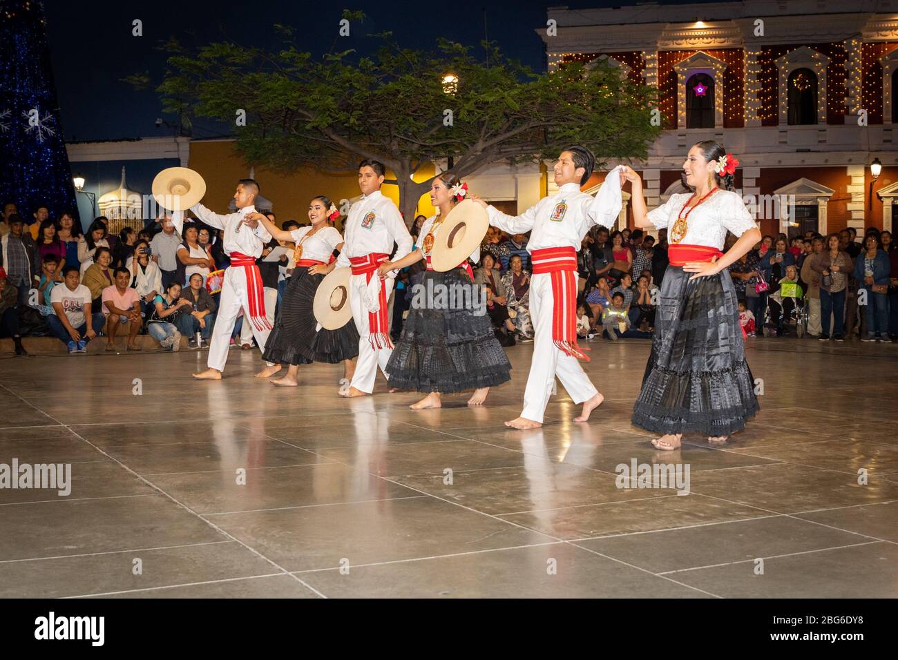 Ballerini maschili e femminili in costume tradizionale che eseguono la Marinera Norteña danza peruviana alla folla nella piazza principale di Trujillo nel nord del Perù Foto Stock