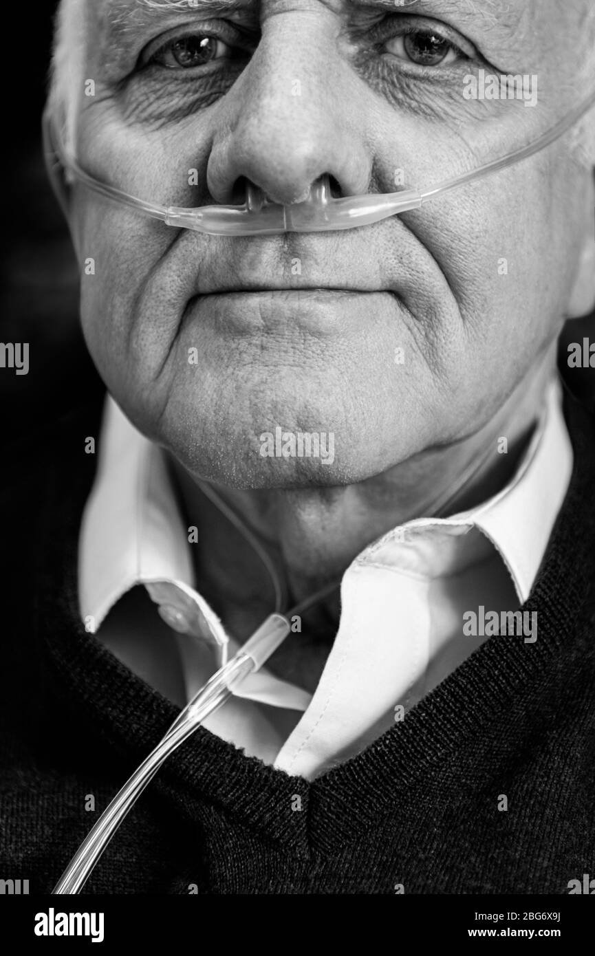 Uomo anziano che indossa il tubo nasale dell'ossigeno. Primo piano ritratto in bianco e nero Foto Stock