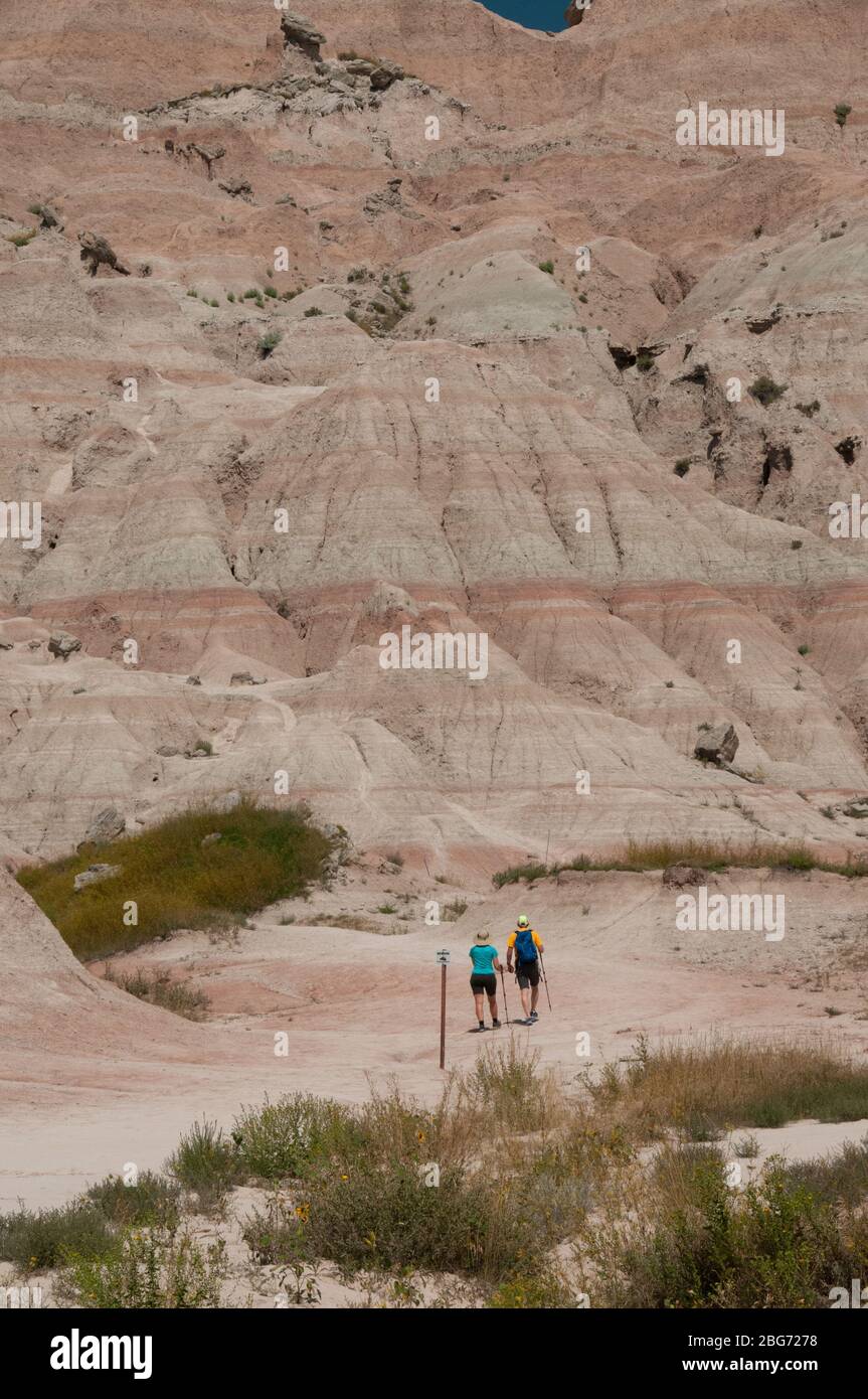 Due persone escursioni nelle Badlands del South Dakota, USA, che mostra la scala delle montagne. Foto Stock