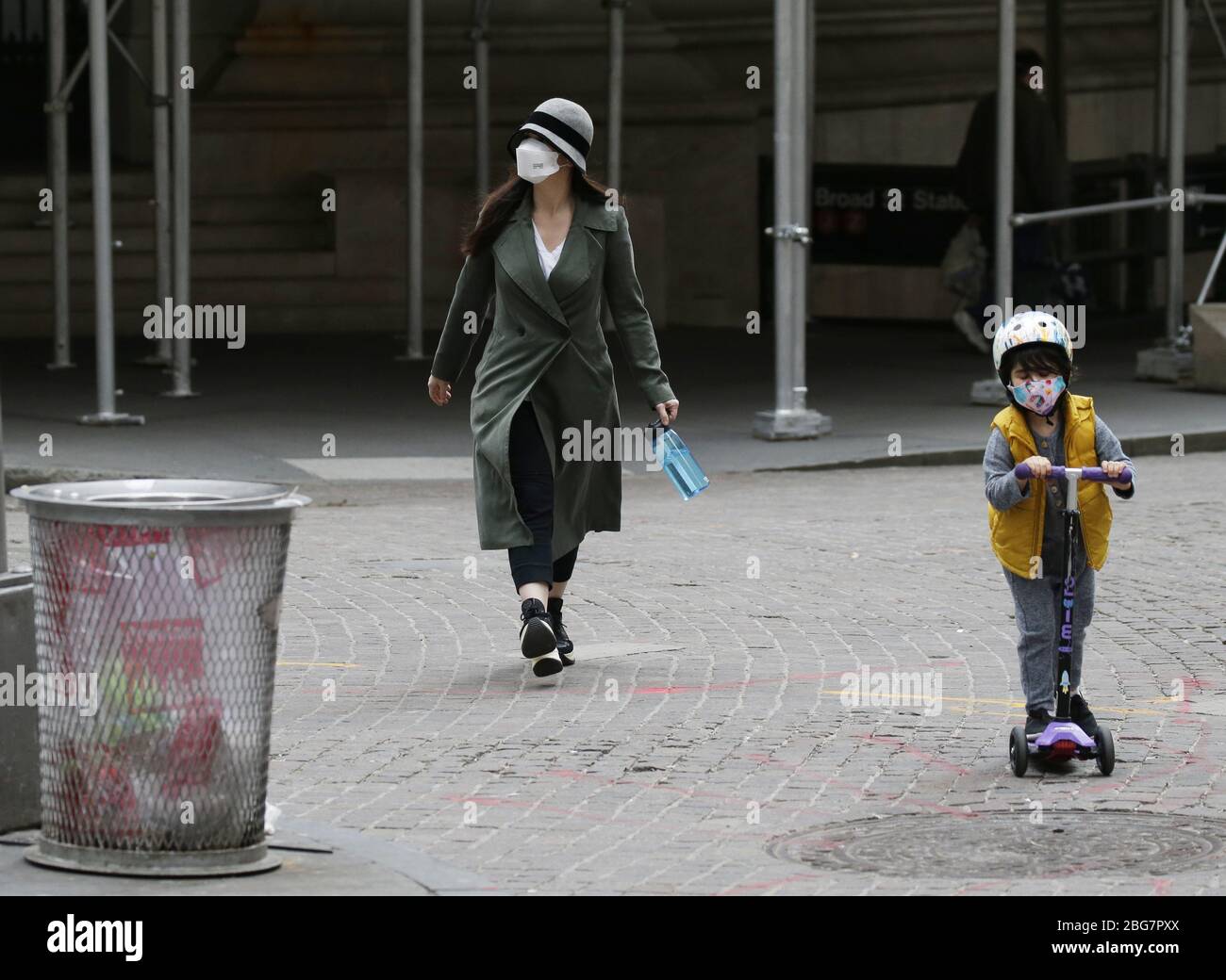 New York, Stati Uniti. 20 aprile 2020. Una donna e un bambino che indossano maschere facciali protettive camminano e cavalcano fuori dalla Borsa di New York a New York City lunedì 20 aprile 2020. Le scorte sono scese il lunedì con il Dow che è sceso quasi 600 punti. I futures petroliferi degli Stati Uniti sono affondati sotto zero per la prima volta nella storia a causa della pandemia di coronavirus. Foto di John Angelillo/UPI Credit: UPI/Alamy Live News Foto Stock