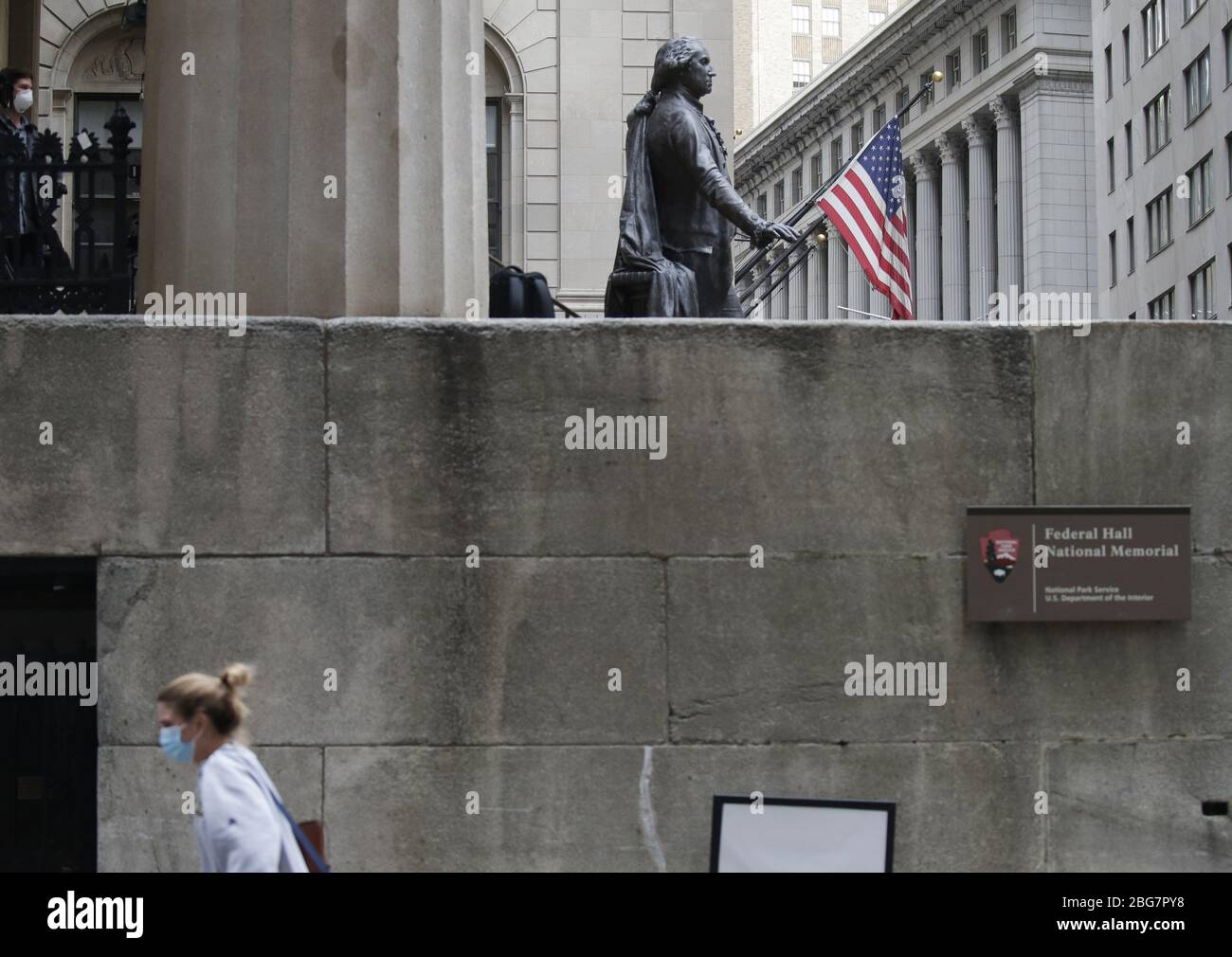 New York, Stati Uniti. 20 aprile 2020. Una donna che indossa una maschera protettiva del viso cammina presso la Federal Hall vicino alla Borsa di New York a New York City il lunedì 20 aprile 2020. Le scorte sono scese il lunedì con il Dow che è sceso quasi 600 punti. I futures petroliferi degli Stati Uniti sono affondati sotto zero per la prima volta nella storia a causa della pandemia di coronavirus. Foto di John Angelillo/UPI Credit: UPI/Alamy Live News Foto Stock