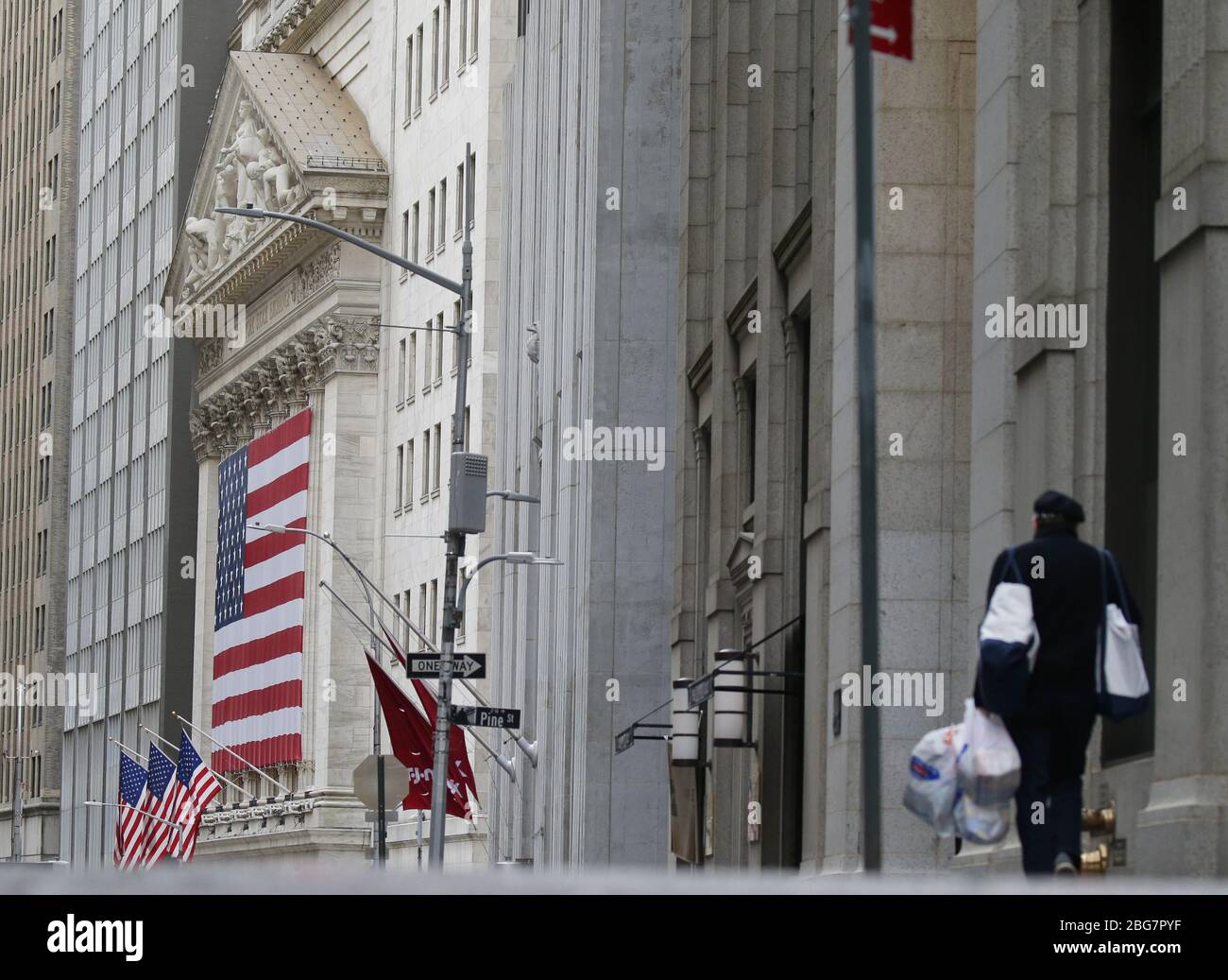 New York, Stati Uniti. 20 aprile 2020. Un uomo che trasporta le borse della drogheria cammina nella direzione della borsa di New York a New York City il lunedì 20 aprile 2020. Le scorte sono scese il lunedì con il Dow che è sceso quasi 600 punti. I futures petroliferi degli Stati Uniti sono affondati sotto zero per la prima volta nella storia a causa della pandemia di coronavirus. Foto di John Angelillo/UPI Credit: UPI/Alamy Live News Foto Stock