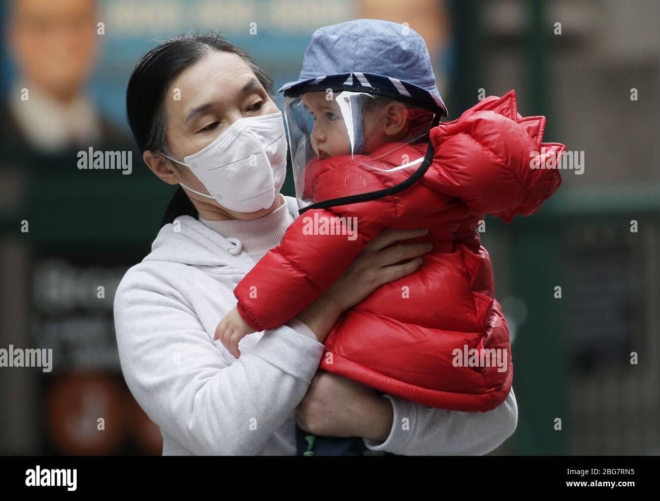 New York, Stati Uniti. 20 aprile 2020. Una donna e un bambino indossano maschere protettive per il viso al di fuori della Borsa di New York a New York City lunedì 20 aprile 2020. Le scorte sono scese il lunedì con il Dow che è sceso quasi 600 punti. I futures petroliferi degli Stati Uniti sono affondati sotto zero per la prima volta nella storia a causa della pandemia di coronavirus. Foto di John Angelillo/UPI Credit: UPI/Alamy Live News Foto Stock