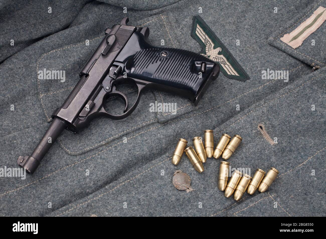 Era la seconda guerra mondiale esercito tedesco nazista 9 mm pistola semiautomatica con munizioni su sfondo grigio esercito uniforme Foto Stock