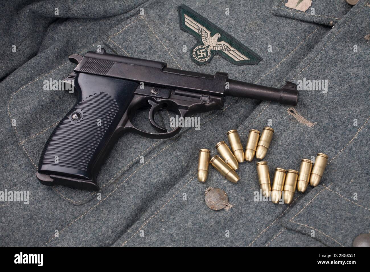 Era la seconda guerra mondiale esercito tedesco nazista 9 mm pistola semiautomatica con munizioni su sfondo grigio esercito uniforme Foto Stock