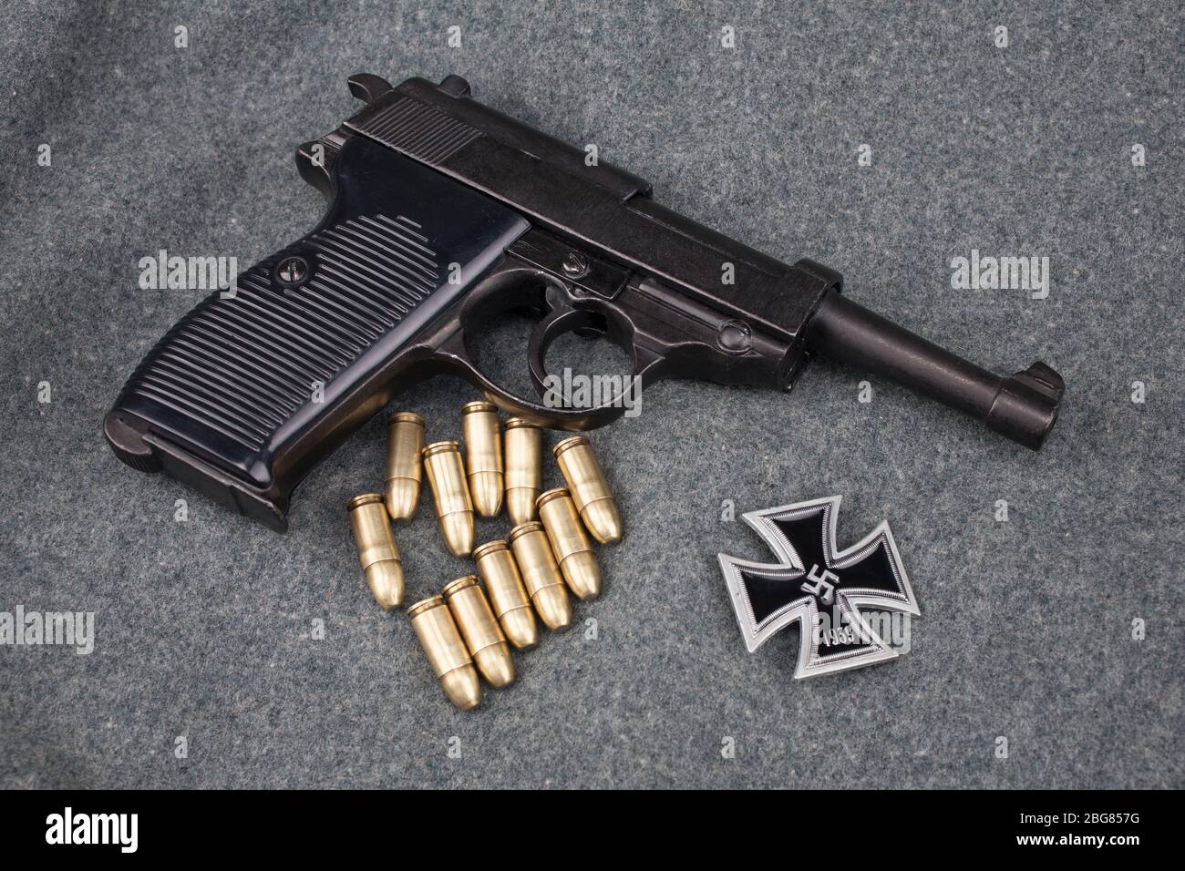 Era la seconda guerra mondiale l'esercito tedesco nazista 9 mm pistola semiautomatica con Iron Cross premio su sfondo grigio esercito uniforme Foto Stock