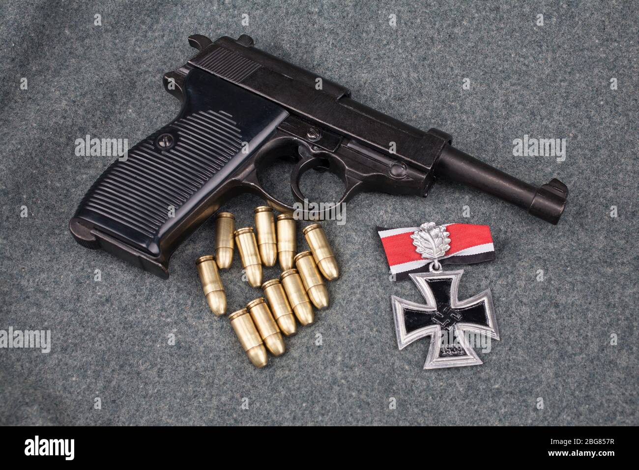Era la seconda guerra mondiale l'esercito tedesco nazista 9 mm pistola semiautomatica con Iron Cross premio su sfondo grigio esercito uniforme Foto Stock