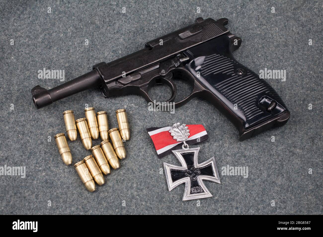 Era la seconda guerra mondiale l'esercito tedesco nazista 9 mm pistola semiautomatica con Iron Cross premio su sfondo grigio esercito uniforme Foto Stock