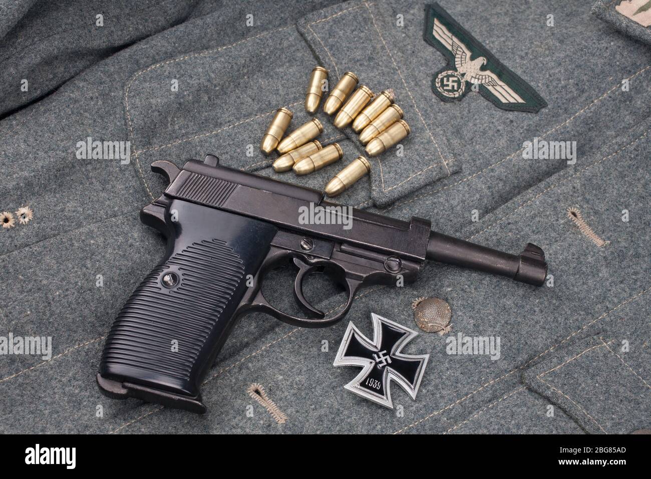 Era la seconda guerra mondiale l'esercito tedesco nazista 9 mm pistola semiautomatica con Iron Cross premio su sfondo grigio esercito uniforme Foto Stock