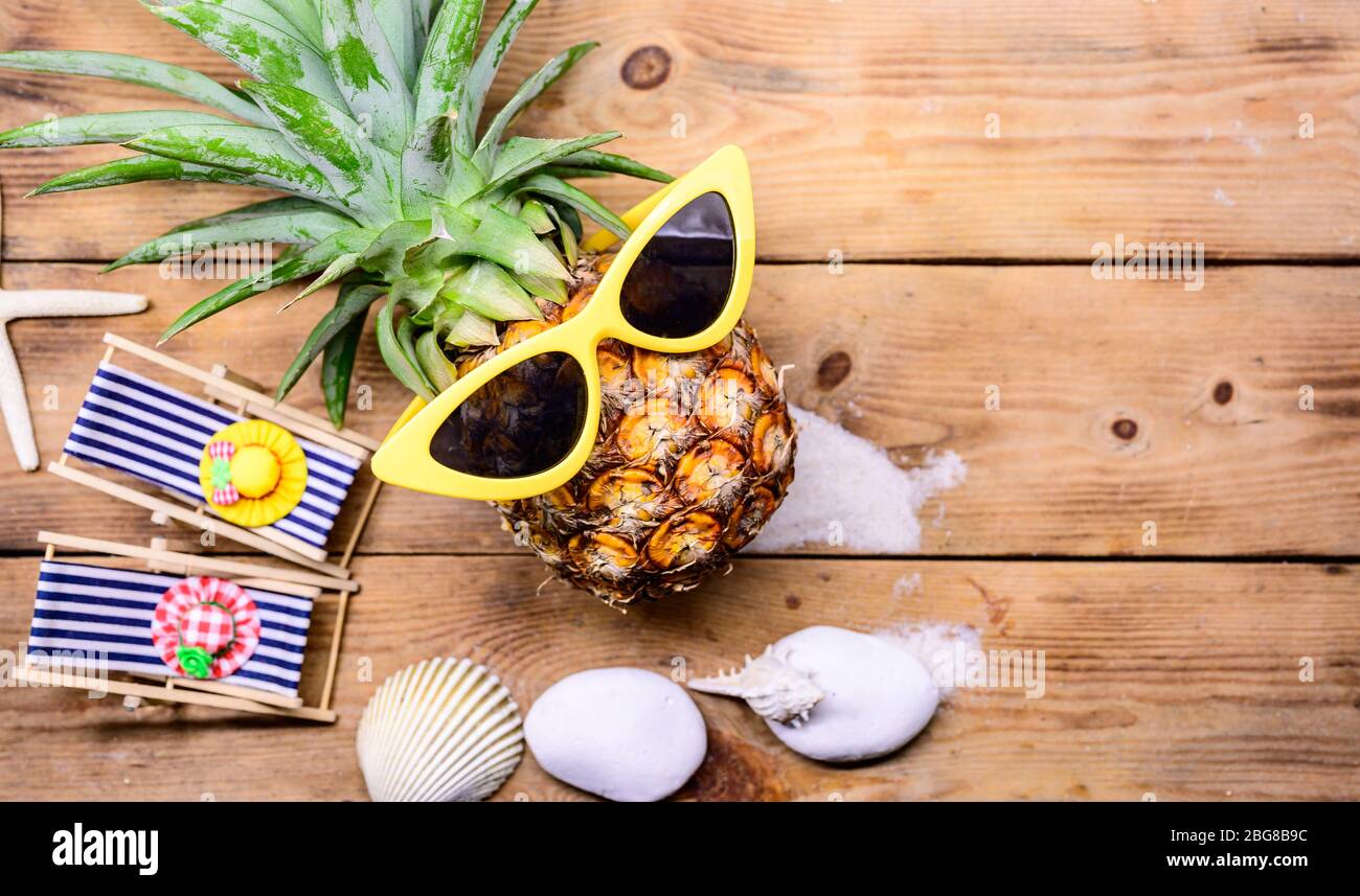 Ananas con occhiali da sole su sfondo di legno. Concetto creativo di  vacanza estiva minima con giocattolo in miniatura Foto stock - Alamy