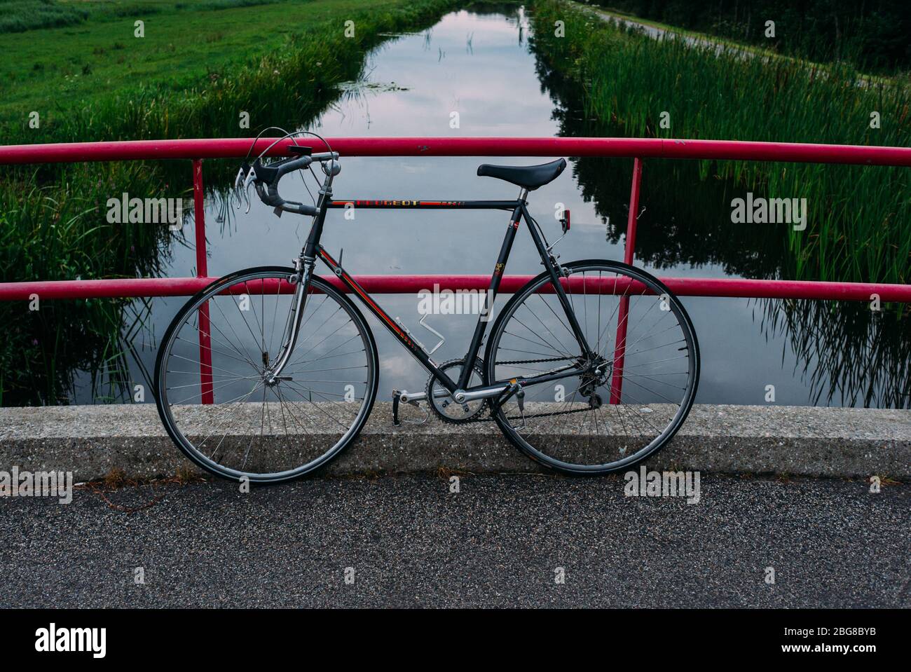 bicicletta da corsa vintage peugeot appoggiata su un ponte rosa, canale con  linea verde sullo sfondo Foto stock - Alamy