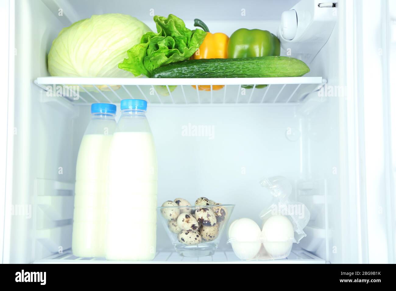 Bottiglie di latte, verdure e frutta in frigorifero aperto. Perdita di peso  concetto di dieta Foto stock - Alamy
