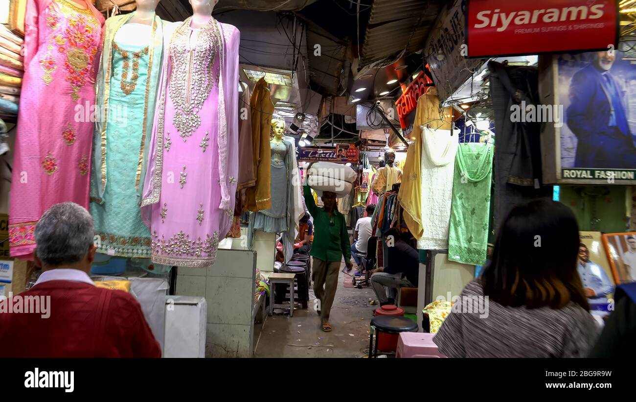 DELHI, INDIA - 12 MARZO 2019: A piedi oltre negozi che vendono saris nella vecchia delhi Foto Stock