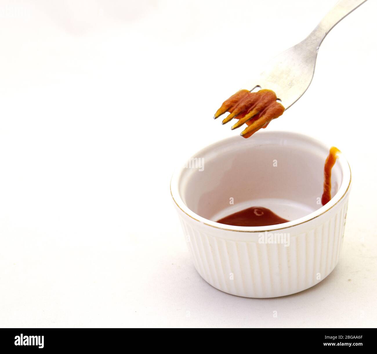 L'uso di una forchetta per raccogliere la zuppa di pomodoro da una ciotola è un'immagine di esercizio inutile in formato orizzontale Foto Stock