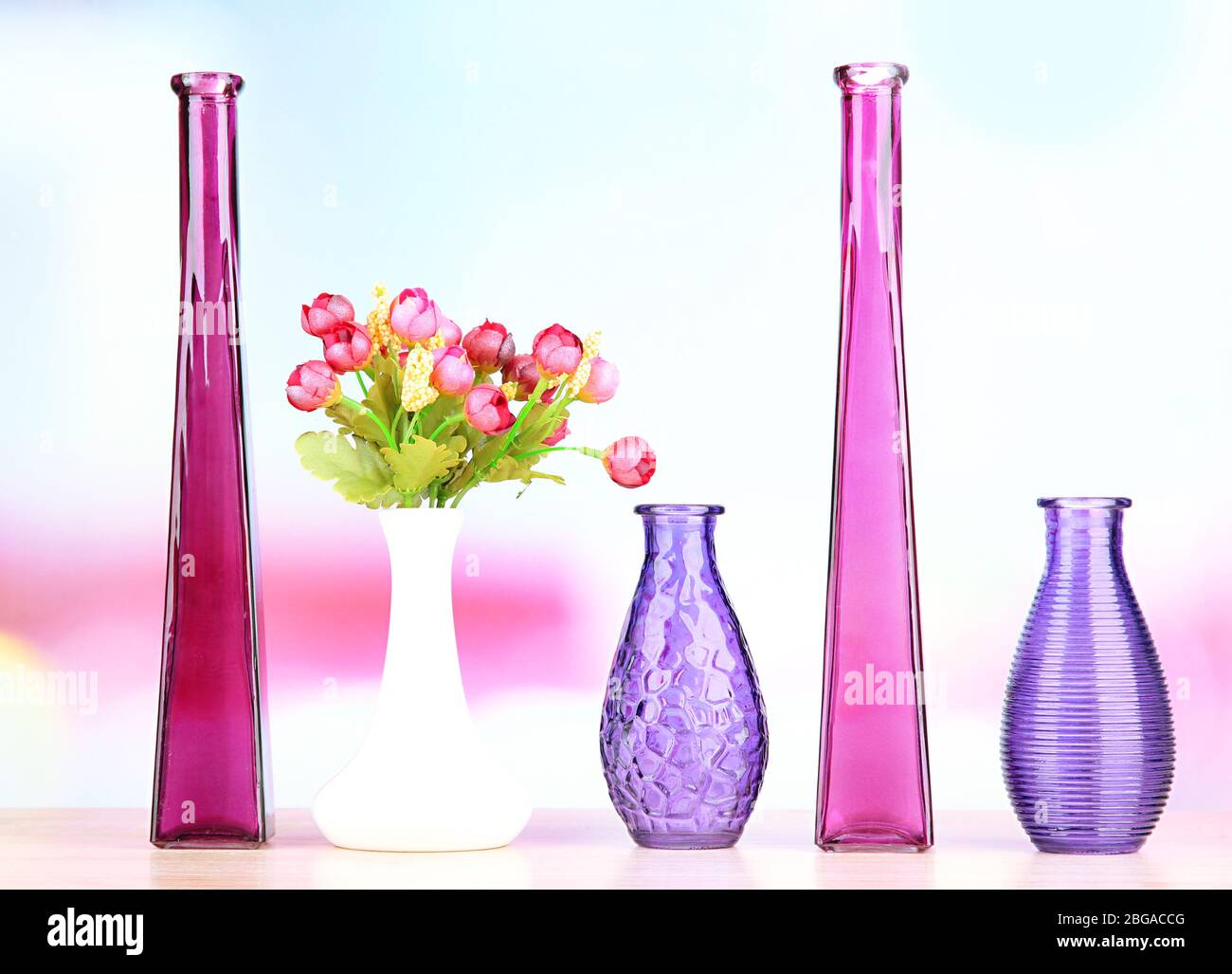 Diversi vasi decorativi su ripiano su sfondo chiaro Foto Stock