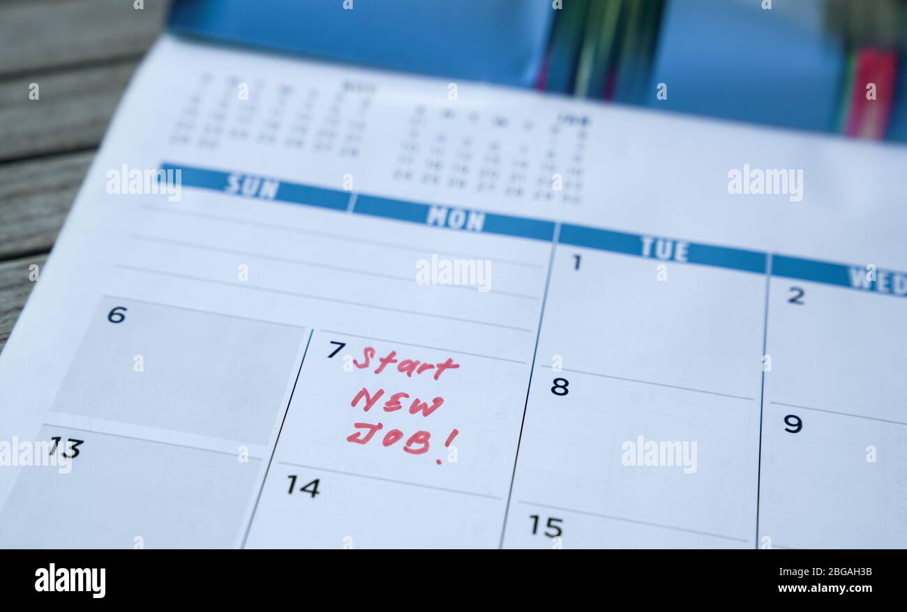 Avviare nuove parole di lavoro scritte sul calendario della tabella con un indicatore rosso. Concetto di occupazione o di carriera. Foto Stock