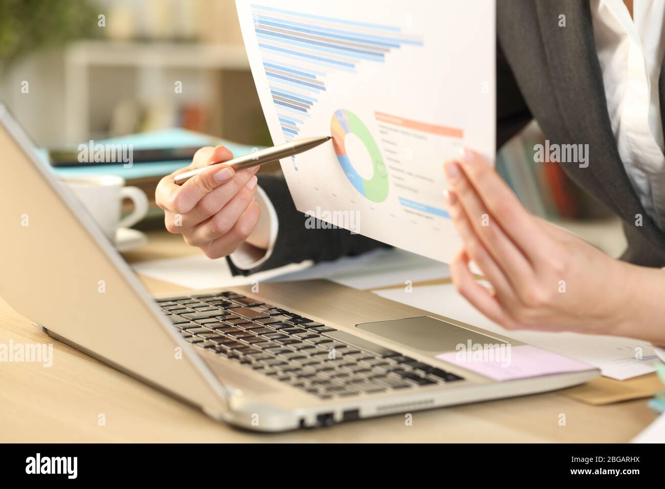 Primo piano di donna imprenditore mani su videocall mostrando grafico di crescita report su un notebook webcam su una scrivania a casa Foto Stock