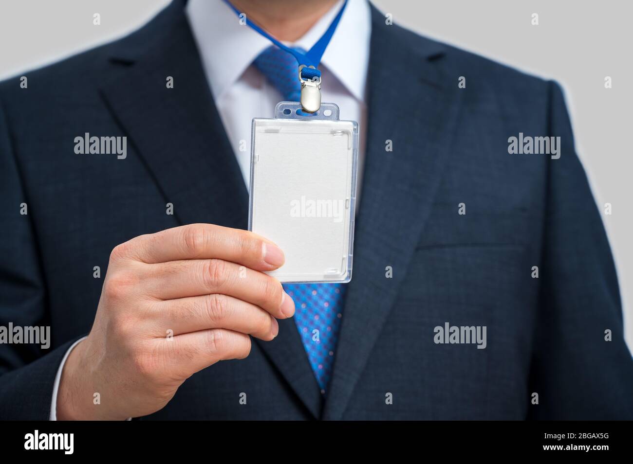 Imprenditore della tuta che indossa un vuoto tag ID o nome scheda su un cordino a una fiera o conferenza Foto Stock