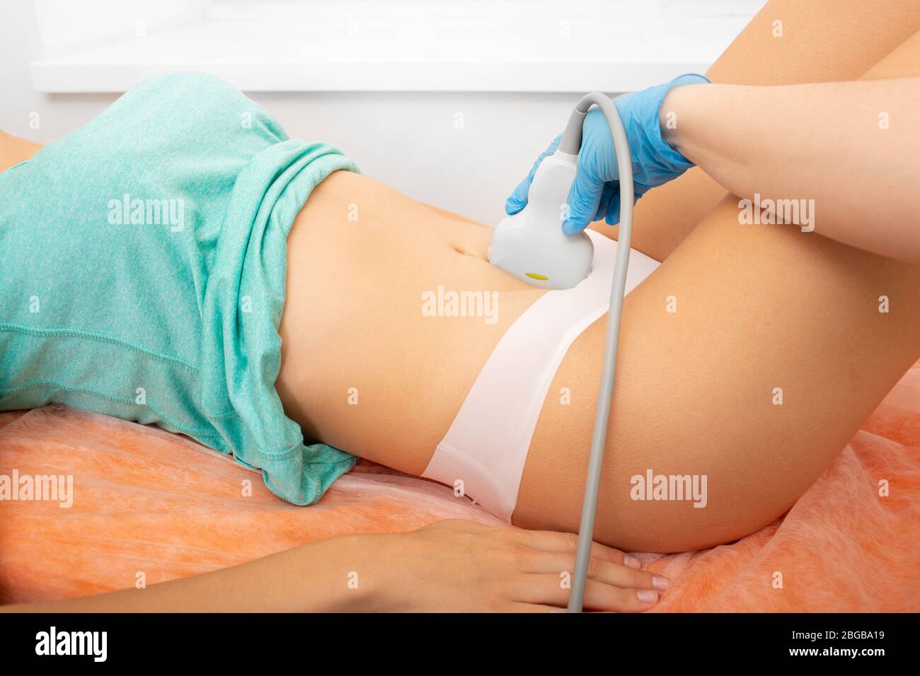 Ecografia ovarica, dispositivo ecografico sullo stomaco del paziente. Esame sanitario femminile Foto Stock