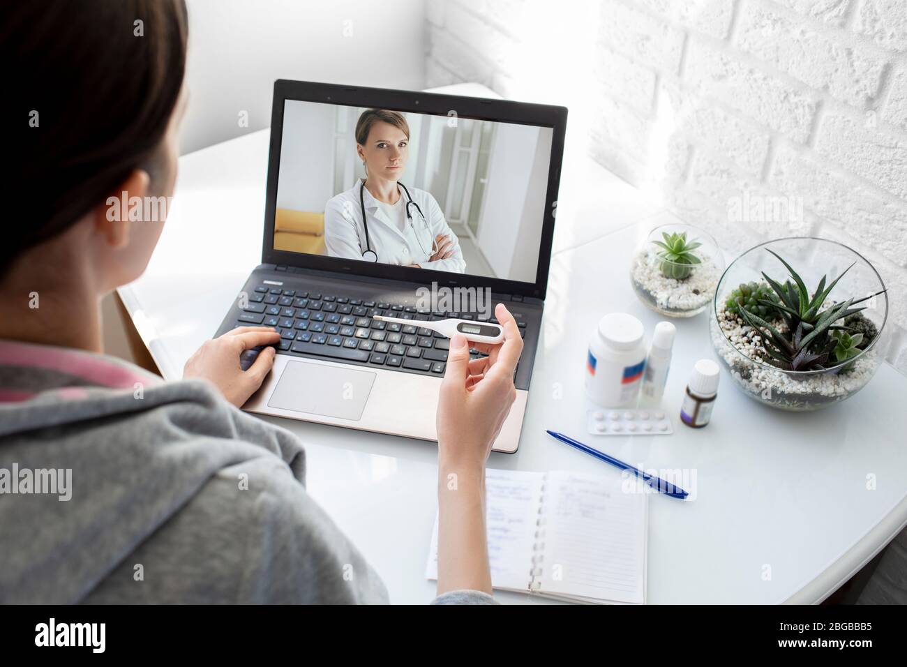 Una donna con una febbre alta ha avuto l'influenza, una consultazione online con il suo medico terapeuta. tecnologia medica, video chat con un medico Foto Stock