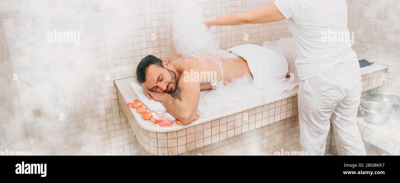 Turco che riceve massaggio schiuma al hammam , spa fine settimana. Bagni orientali tradizionali Foto Stock