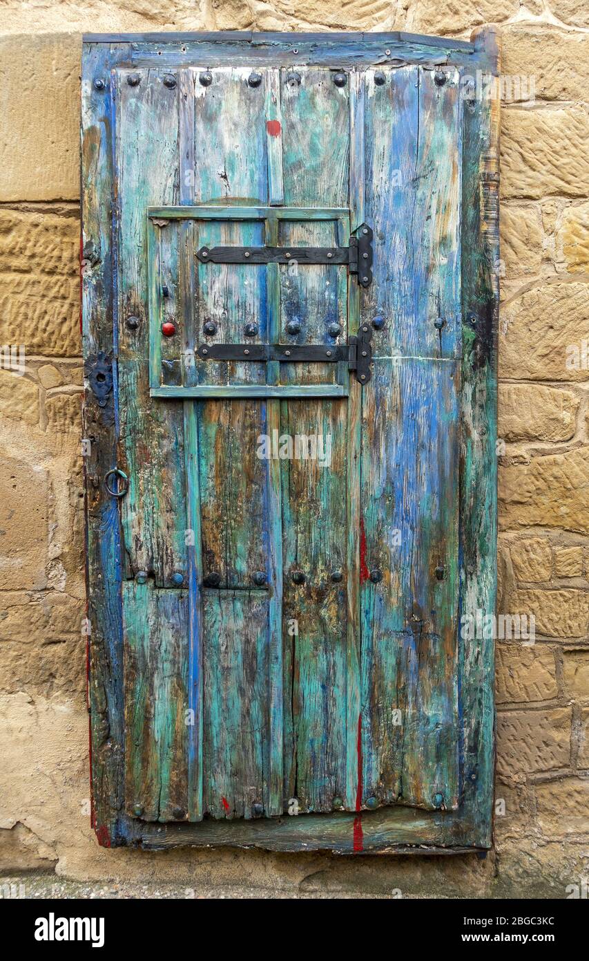 Tempo battuto vecchio rustico tradizionale porta di legno che mostra le varie strati di vernice e colore Foto Stock