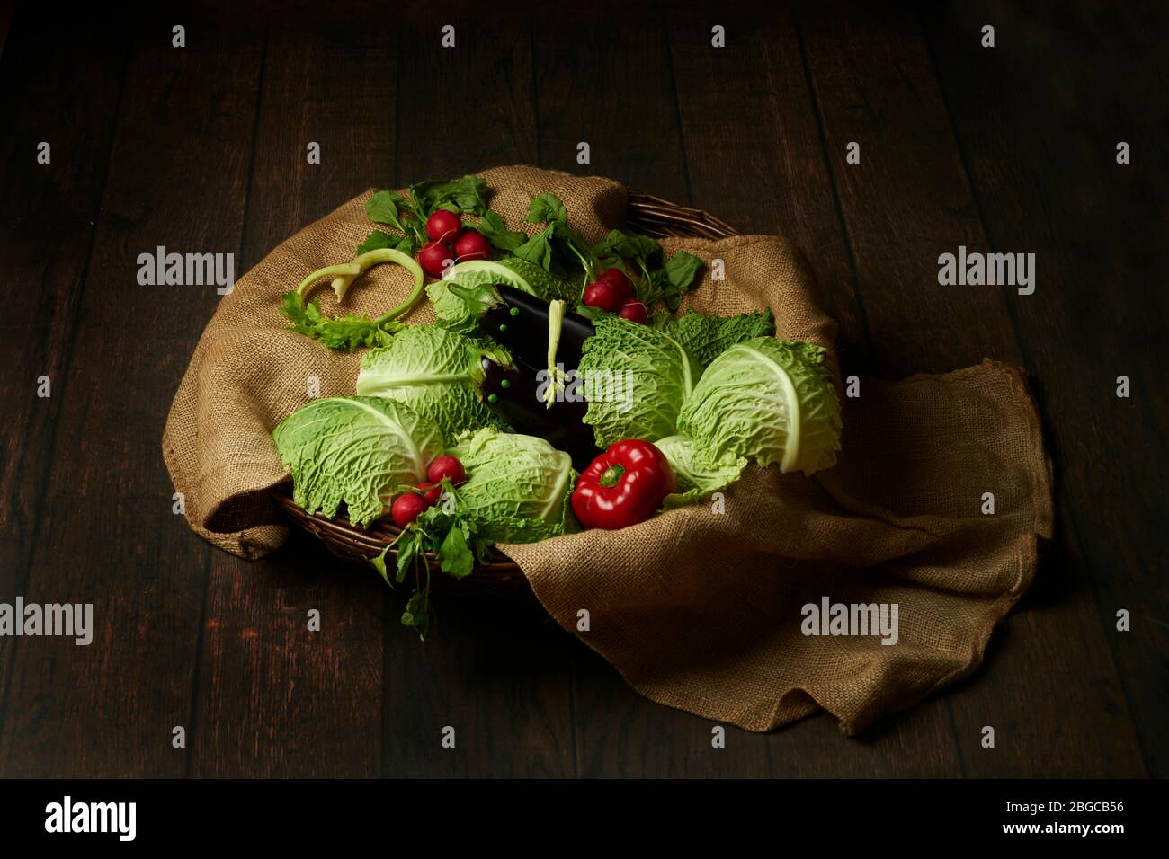 Verdure in studio di fotografia. Divertente posa di verdure art. Melanzane uovo-pianta posto come bambini circondato da rafano di pepe di cavolo. Foto Stock