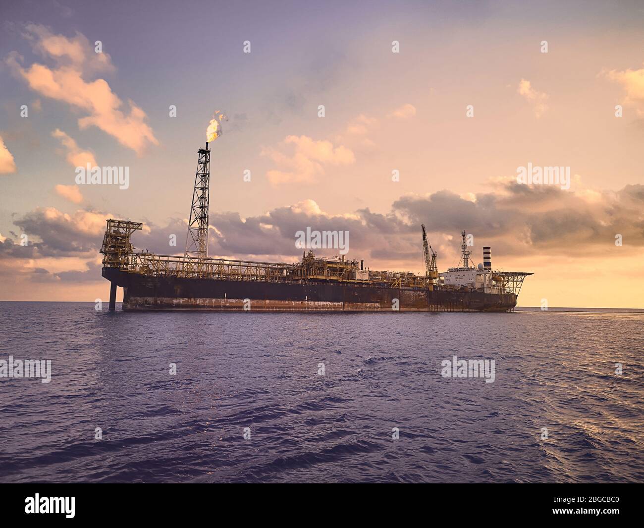 Stoccaggio e scarico in mare durante il tramonto della produzione galleggiante FPSO Foto Stock