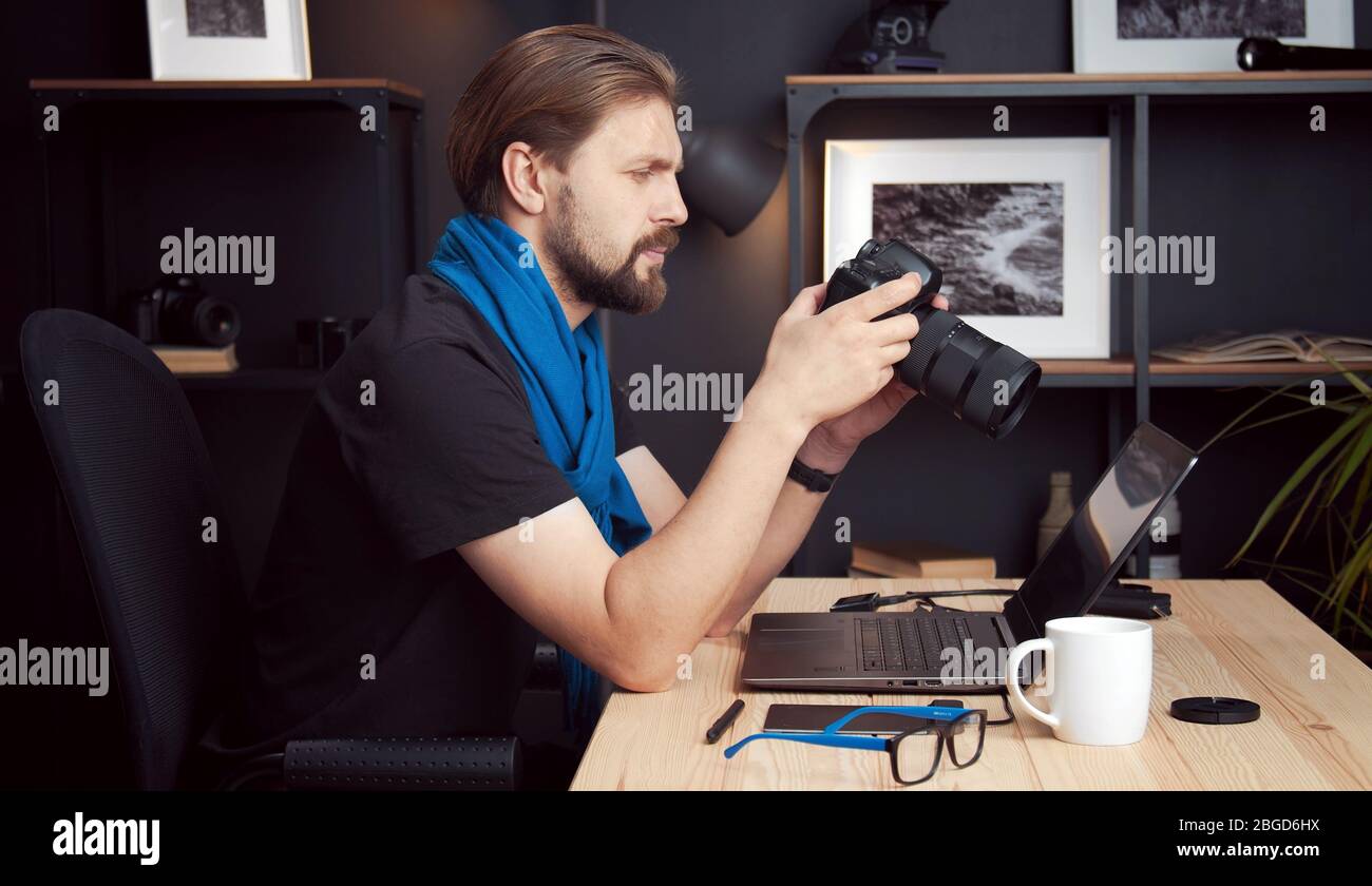Fotografo che riesamina gli scatti, vista laterale Foto Stock