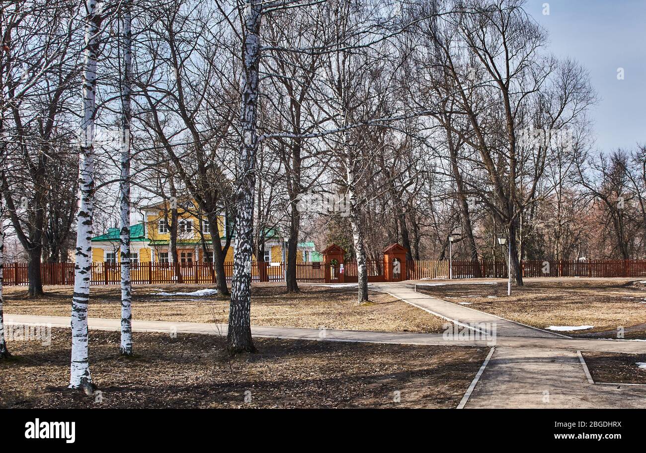 Casa di villaggio in legno nel parco della proprietà della famiglia Pushkin. Portico, finestre, tetto. La casa è circondata da alberi. Russia, Boldino Foto Stock