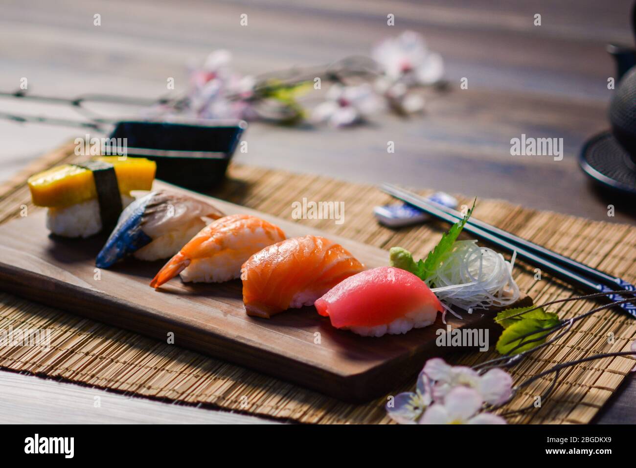 Mescolare il sushi sul piatto a legna, il tonno, il salmone, il branzino, l'uovo dolce, Sushi di gamberi, cibo giapponese. Cibo giapponese sul piatto. Foto Stock