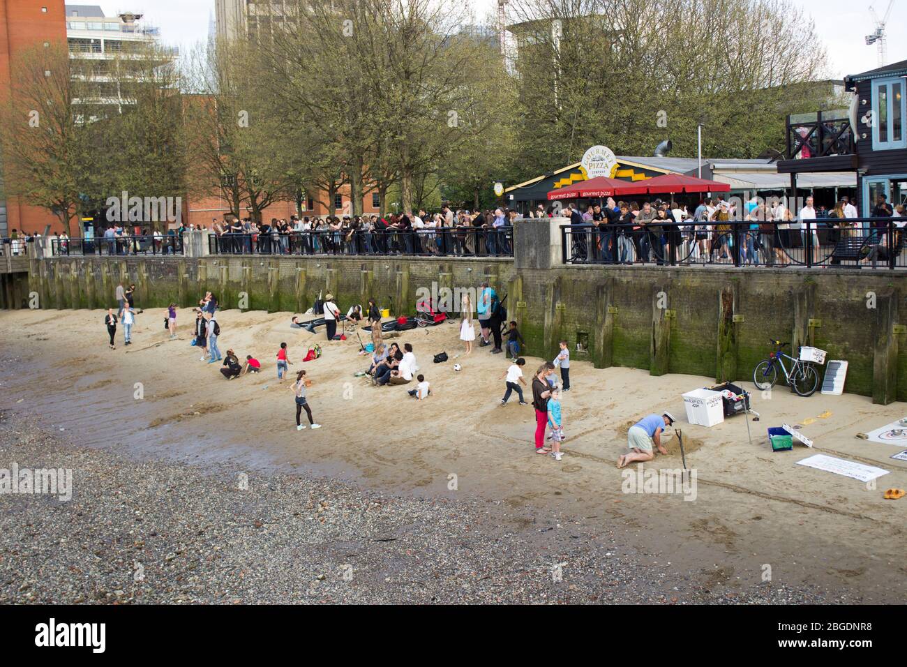 La folla si soleggia e gioca sulla spiaggia del Tamigi Foto Stock