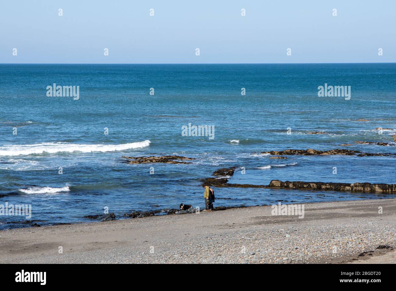 Aberystwyth, Ceredigion, Galles, Regno Unito. 21 Aprile 2020 Regno Unito Meteo: Quasi spiaggia vuota con cielo blu e sole mentre la gente cammina i loro cani lungo la spiaggia sud di Aberystwyth, come da linee guida del governo di esercizio quotidiano consentito. © Ian Jones/Alamy Live News Foto Stock