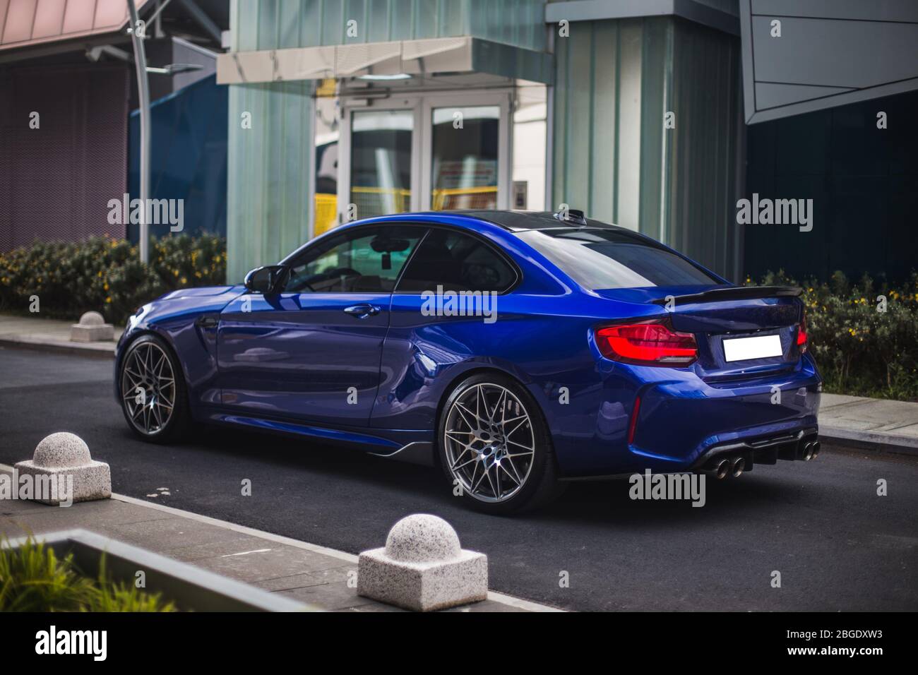 La berlina sportiva Blue è parcheggiata di fronte al business center Foto Stock