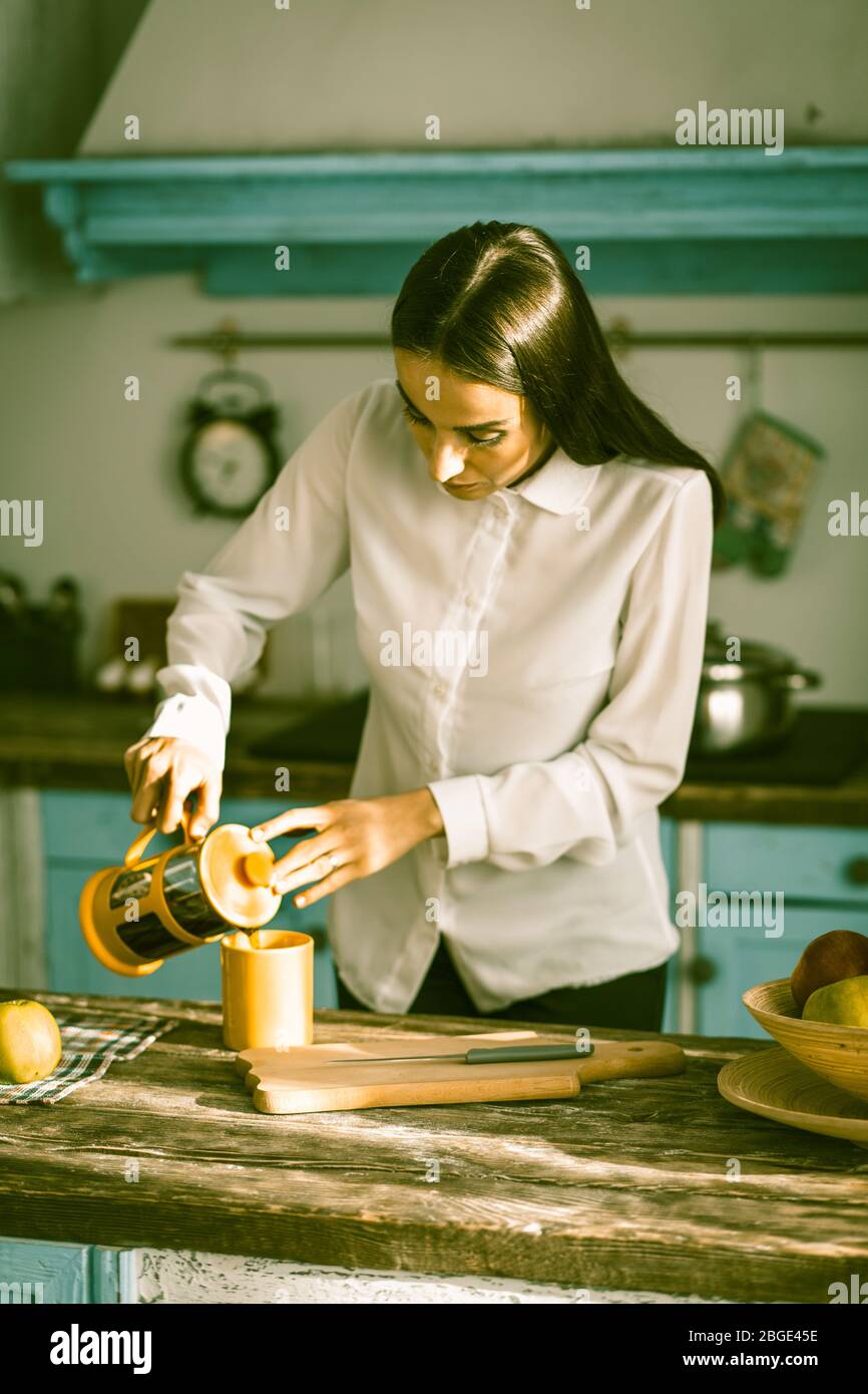 Donna cucina a casa cucina al mattino soleggiato Foto Stock