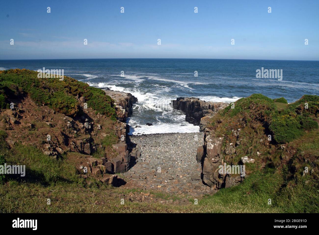 Un vuoto nelle rocce sulla costa del Northumberland nell'Inghilterra settentrionale. Foto Stock