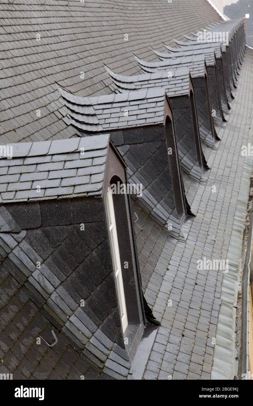 Una linea di finestre dormer piastrellate in un vecchio edificio in Lussemburgo, Europa Foto Stock