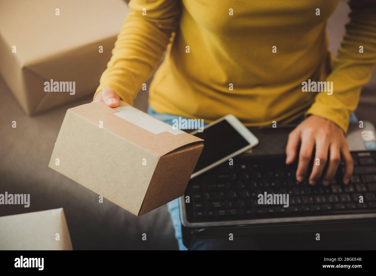 Donna tiene una scatola per prepararsi a consegnare al cliente secondo l'ordine a casa.lavoro da casa e marketing online o avvio di piccole imprese c Foto Stock